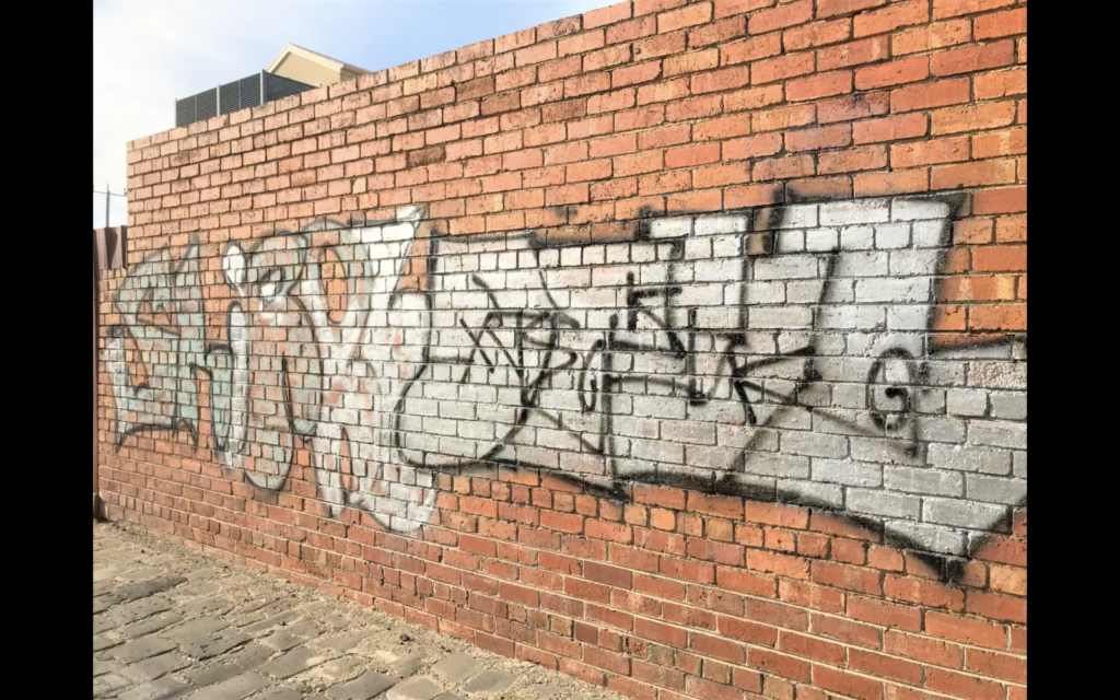 Graffiti entfernen 14 Vorher-Bild einer Graffitireinigung: Vollständige Beseitigung von Sprühfarbe auf Naturstein durch mobile Lasereinheit