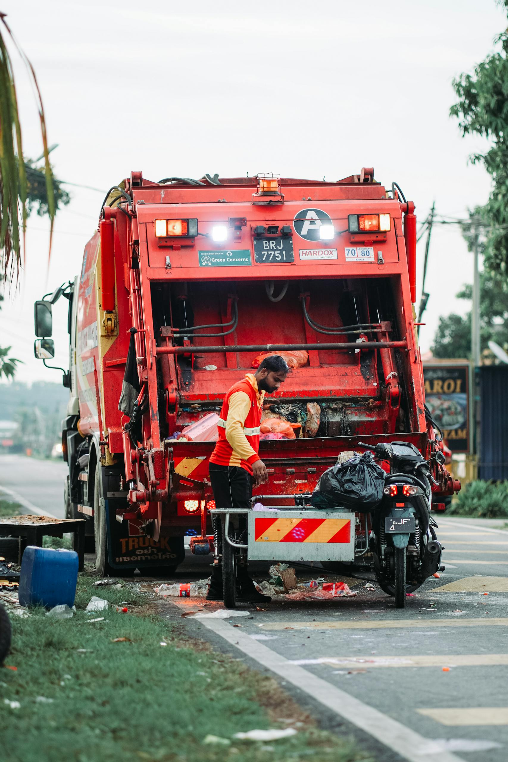 Abfall und Recyclingwirtschaft 12 Laserreinigung Recyclingwirtschaft A sanitation worker managing waste disposal behind a garbage truck in Klang, Selangor.